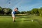 Man teeing off in the tee box, playing golf