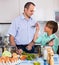 Man and teenager cooking together