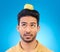 Man, thinking or balance apple on head in studio isolated on a blue background. Confused, fruit or Asian person with