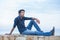 Man thinking sitting on a concrete bridge above the sea