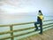 Man thinking. Tourist in warm clothes on sea mole at handrail. Tourist on pier in harbor