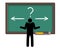 Man thinking which way to go, arrows on blackboard