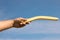 Man throwing boomerang against blue sky, closeup