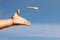 Man throwing boomerang against blue sky, closeup