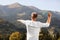 Man throwing boomerang in mountains on sunny day, back view