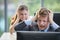 Man throwing computer screen at female co-worker