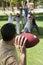 Man throwing football to group