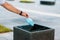 Man throwing used disposable protective surgical mask into the garbage bin