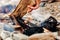 Man throws firewood into a bonfire burning on a stone beach