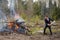 A man throws firewood into a fire. cleaning the cottage, burning garbage. A businessman in a business suit works with