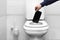 a man throws a mobile phone smartphone into the toilet with his hand. liberation from social dependence and fatigue from