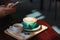 Man took picture with smartphone. Hot Coffee latte with tulip foa
