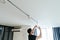 Man with a tool in his hands is repairing a lamp on the ceiling in his house. repair and improvement.