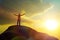 A man at the top of the mountain, raising his hands up against the backdrop of the glare of the sun.