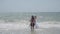 Man tosses daughter standing in endless ocean shallow water
