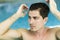 Man touching his hair in the swimming pool