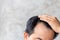 Man touching his head to show bald head or Glabrous problem. Copy space with grey background
