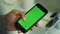 Man touching smartphone with chroma key green screen. Mobile phone