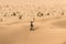 Man tourist in desert rub al khali Oman throwing sand