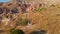 A man tourist hikes through the Red or Pink Valley near Goreme, Cappadocia. The landscape, painted in warm tones