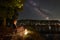 Man tourist resting sitting on chair on lake shore at night