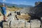 Man tourist standing on ruins of Theatre in Xanthos Ancient Lycia City and taking photo, Turkey. Sunny day, Old Lycian