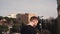 Man tourist stands at Colosseum in Rome, Italy. The handsome male takes smartphone, serves the internet. Slow motion.