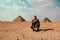 Man tourist traveler posing in the desert at the Saqqara pyramids, belived to be the first pyramids ever built. Cold winter day in