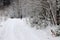 Man in a tracksuit runs along the snowy road.