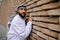 A man in traditional arabian headwear standing near the brick wall