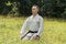 A man in a traditional kimano with a black belt sits and meditates