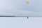 Man training with a kite on a frozen river in winter, Kama Reservoir, Perm city, Russia