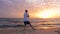Man training martial art Taijiquan on sea beach and evening sunset landscape