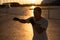 A man trains in boxing at the stadium at sunset. Athlete silhouette.