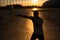 A man trains in boxing at the stadium at sunset. Athlete silhouette.