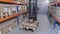 Man transporting gearbox on forklift, warehouse with gearboxes