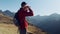 Man travel hiker enjoying the nature while looking the landscape with binoculars in the mountain.