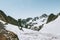 Man traveler with backpack hiking in snowy mountains