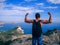 Man traveler with backpack standing with his back to the precipice of the mountain