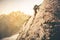 Man Traveler with big backpack climbing on rocks