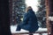 Man traveler forester hunter in the winter forest sitting on fallen tree