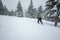 Man traveler goes in snowshoes through the alpine meadow