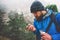 Man traveler with gps navigator in foggy forest