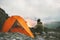 Man traveler relaxing in mountains near of tent camping