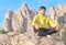 Man Traveler Relaxing Yoga Meditation sitting on stones with Rocky Mountains