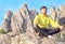 Man Traveler Relaxing Yoga Meditation sitting on stones with Rocky Mountains