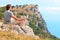 Man Traveler Relaxing Yoga Meditation sitting on stones with Rocky Mountains and blue sky on Background