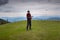 Man traveler, with remote controller of drone, stands on the alp