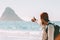 Man traveler showing rock in the ocean enjoying landscape