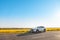 man traveler sitting near car at roadside of speedway at sunset